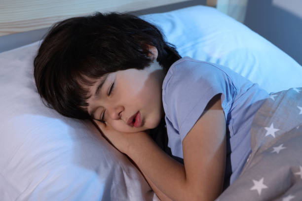 istock Cute little boy sleeping in bed at home 1435293754
