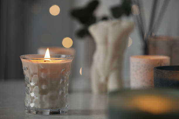 istock Beautiful burning candle on white table in room, space for text 1435295764