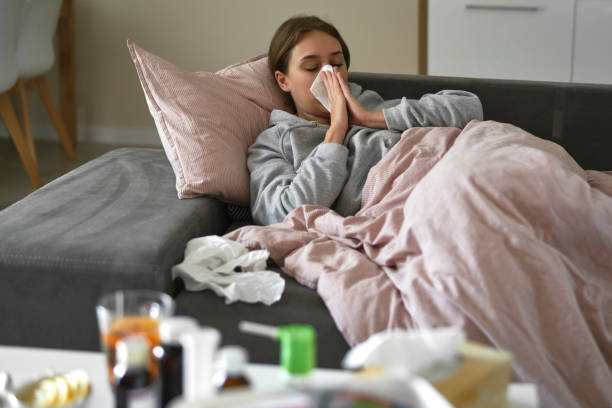 istock Caucasian woman lying on sofa with flu at home 1435297776
