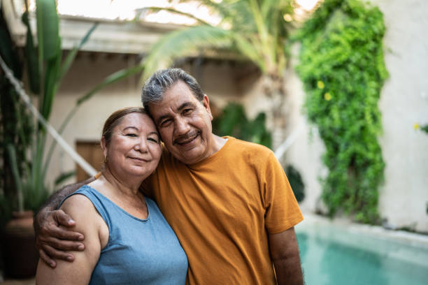 retrato de pareja madura abrazada junto a la piscina - couple healthy lifestyle real people characters fotografías e imágenes de stock