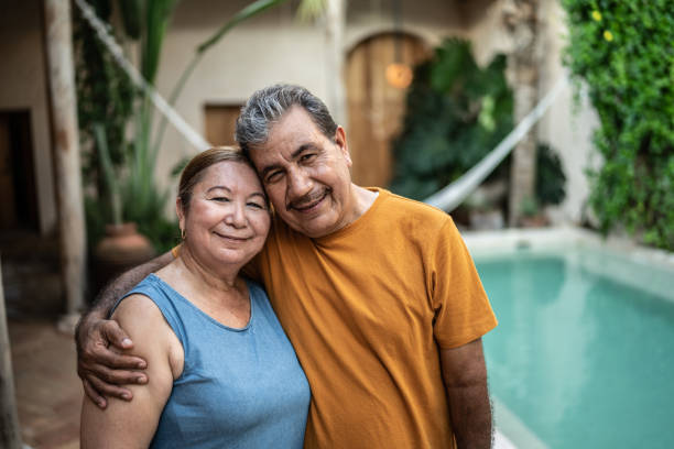 portret dojrzałej pary obejmującej się przy basenie - latin american and hispanic ethnicity senior adult mature adult couple zdjęcia i obrazy z banku zdjęć