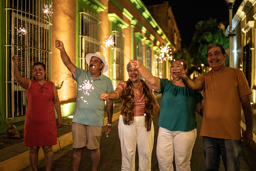 Senior friends celebrating new years with bengal lights at the historic district