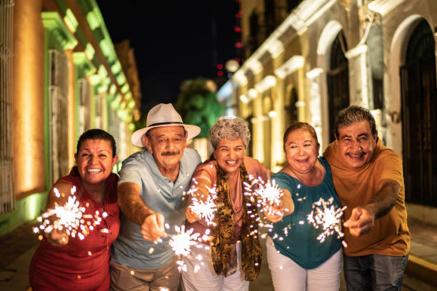 Portrait of senior friends celebrating new years with bengal lights at the historic district Portrait of senior friends celebrating new years with bengal lights at the historic district firework display pyrotechnics celebration excitement stock pictures, royalty-free photos & images