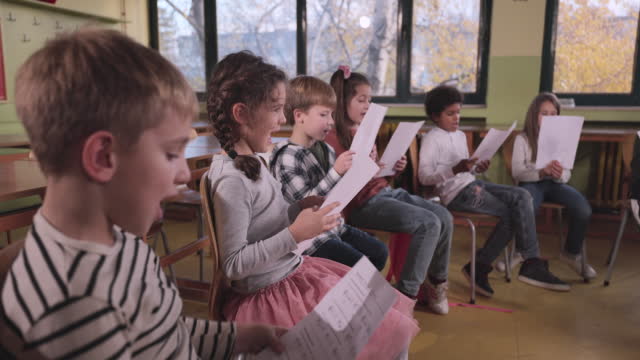 School children practicing with sheet music on a class at school.