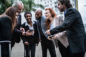Business people looking for mobile phone on a business meeting outdoors