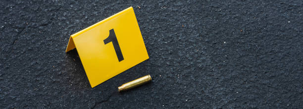 crime scene marker next to bullet casing - csi imagens e fotografias de stock