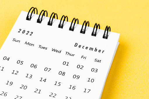 El calendario mensual de escritorio de diciembre de 2022 para el año 2022 sobre fondo amarillo. photo
