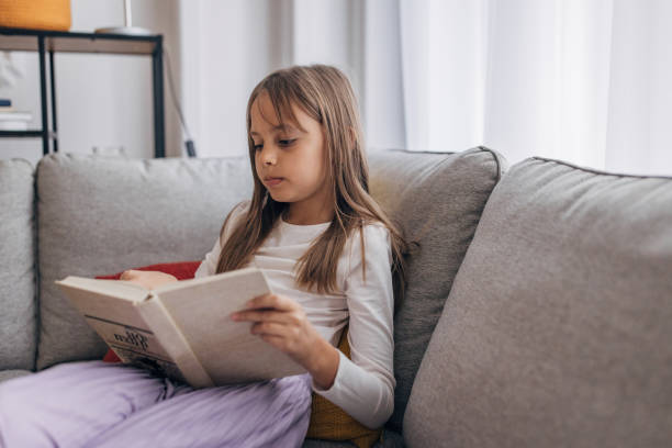 istock Cute girl reading a book 1435308947