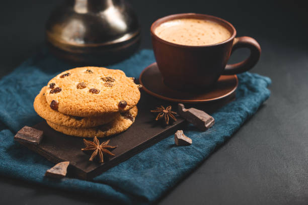 istock Crispy oatmeal cookies with raisins, coffee cup and turkish coffee pot, chocolate chunks on a dark background 1435309487