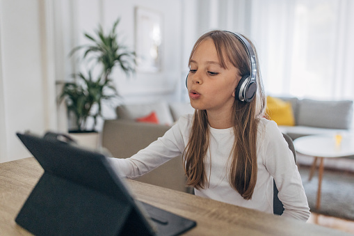 One girl, young girl having fun listening music on headphones at home.