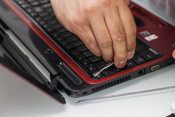 istock man opens an old laptop for disassembly 1435312394