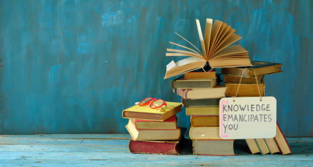 istock stack of books and an open book with slogan knowledge emancipates you, learning is the key to a better life. Free copy space 1435313941