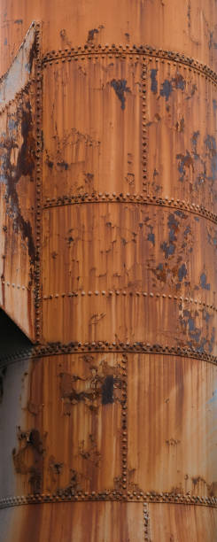istock Corroded metal smokestack with paint, rust and rivets. 1435314974