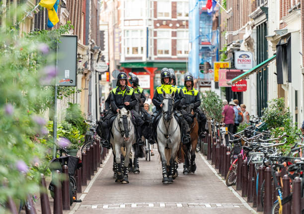 Amsterdam, Netherlands - A group of police officers on horseback on a street in Amsterdam's city centre.