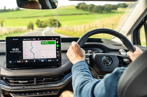 South Lanarkshire, Scotland - A man driving a Skoda Enyaq on a winding section of the A702, following a route planned on Google Maps using Android Auto.