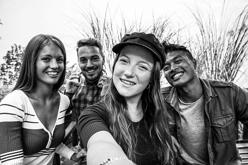 Multicultural guys and girls taking selfie outdoors - Happy friendship concept on young multiethnic people having fun day together