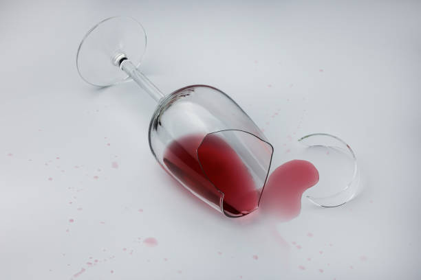 istock Broken glass with spilled wine on a light background 1435325639