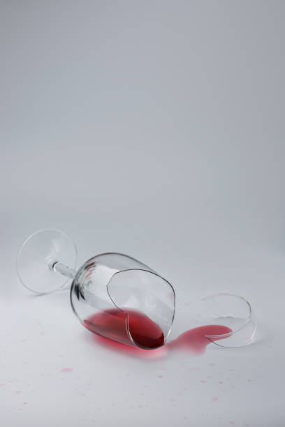 istock Broken glass with spilled wine on a light background 1435325919