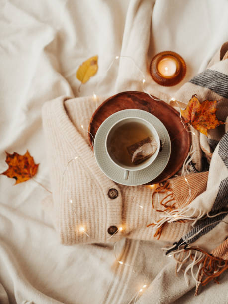 istock Cozy autumn tea cup still life with soft sweaters and lights 1435328374
