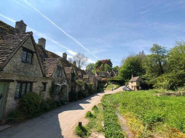 istock Vertical low-angle of a road leading to the Cotswolds AONB trees on both sides, clear sky background 1435330740