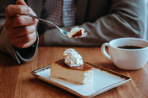 crema di cheesecake e caffè serviti sul tavolo, uomo che mangia cheesecake, - coffee cake foto e immagini stock