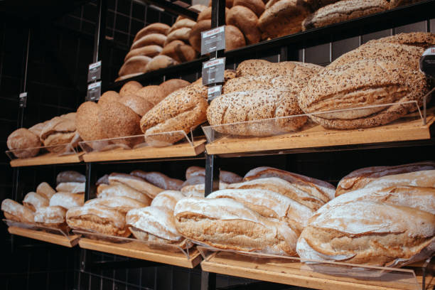 istock Table decorated with various artisan breads produced, Freshly baked handmade sourdough breads, Still life with bread and wheat, Factory for the production of bakery products, breads on the oven counter 1435344039