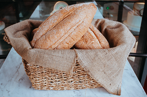 A group of bread loaves, breads in a wicker basket on the table, Freshly baked breads, sesame and grain breads