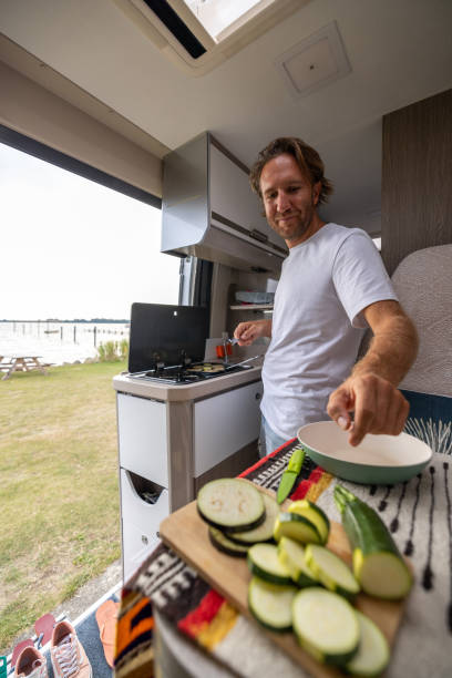 istock Living the van life, young man inside camper van cooking 1435344928