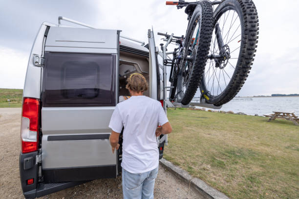 istock Young man adjusting mountain bikes on his van 1435345726