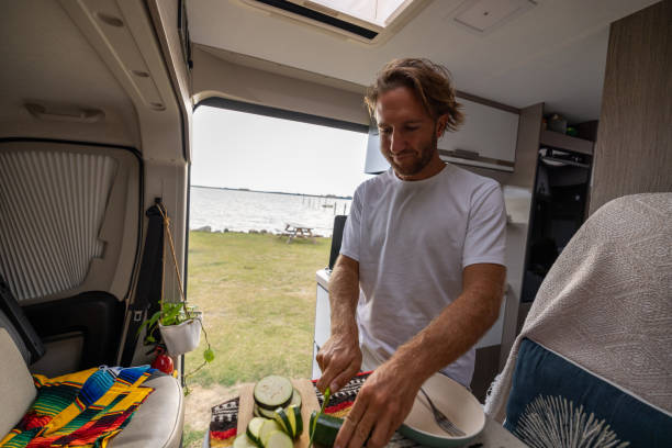 istock Living the van life, young man inside camper van cooking 1435346187