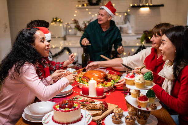 istock Multi-ethnic big family celebrating Christmas party together in house. Attractive diverse group of people having dinner eating food to celebrate holiday Thanksgiving, X-mas eve on dining table at home 1435347318