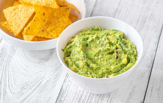 Bowl of guacamole with tortilla chips on the table