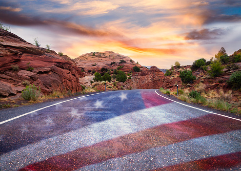 Empty road with American flag at sunset. Patriotism, election, voting, politics, government, freedom.