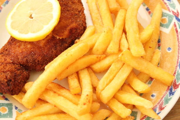 French fries and a wiener schnitzel with lemon on a plate