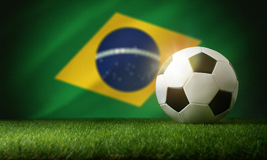 Brazil national team composition with classic ball on grass and flag in the background. Front view.