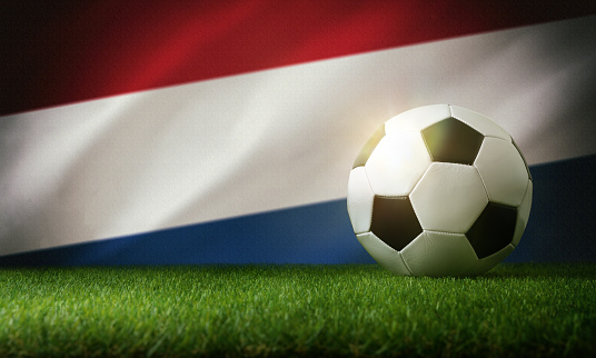 Netherlands national team composition with classic ball on grass and flag in the background. Front view.