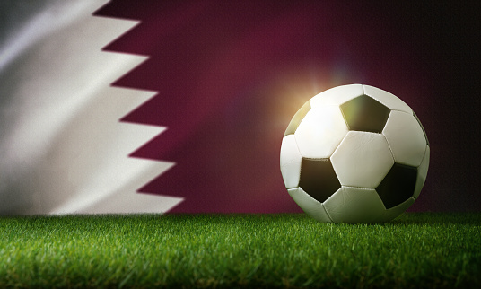 Qatar national team composition with classic ball on grass and flag in the background. Front view.