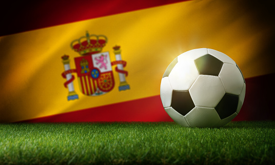 Spain national team composition with classic ball on grass and flag in the background. Front view.
