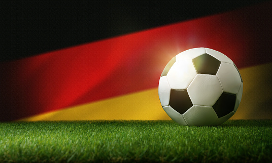 Germany national team composition with classic ball on grass and flag in the background. Front view.