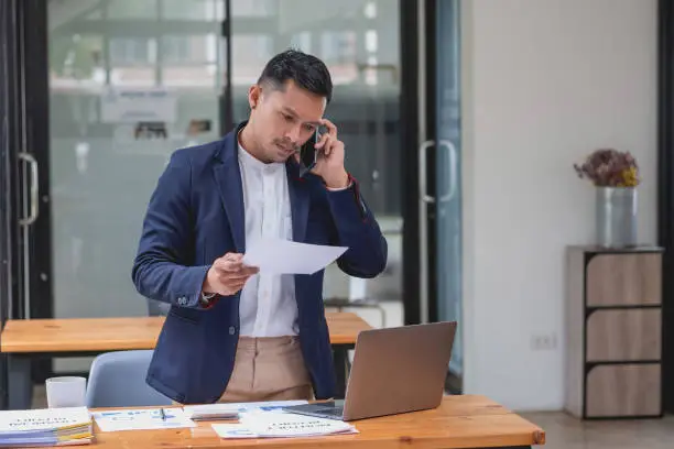 Photo of Marketing, Financial, Accounting, Planning, businessman uses a mobile phone to contact a customer to inform her of the company is business partnership.