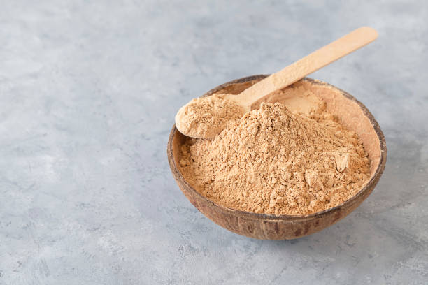 istock Maca root powder - a small bowl with a spoon on neutral background with space for text 1435362524