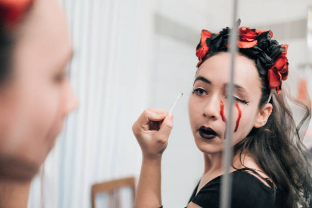 istock girl putting on makeup for halloween 1435363960