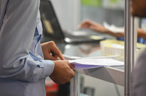 Close-up of a man at the bank counter, finishing some paperwork