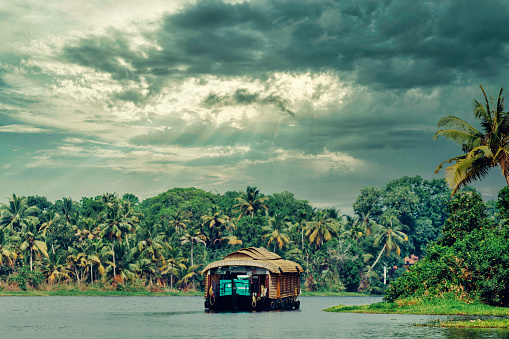 Houseboat navigating on the Kerala Backwaters in South India.