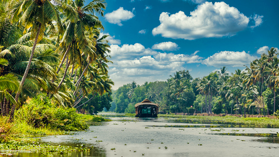 Kannur, India - December 10, 2011: Fisherman prepares to set out on a fishing trip in a small traditional boat along Cherai beach near Thottada village, 10 km south of Kannur, Kerala, India. The shot shows the coconut palms lining the beach along the Malabar coastline.