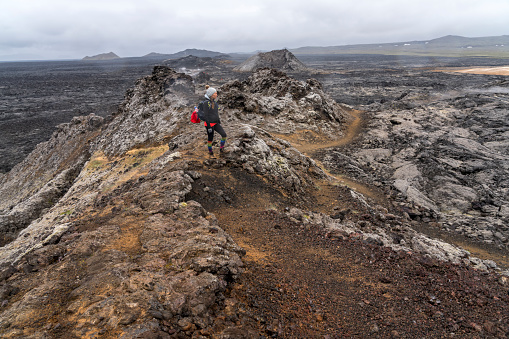Geothermal area of Leirhnjukur, Krafla lava fields, one women standigh on top, Iceland