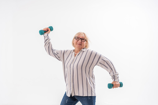 Happy aged  senior woman exercising over white background