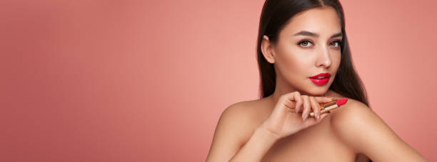 istock A beautiful young woman applying lipstick 1435374202