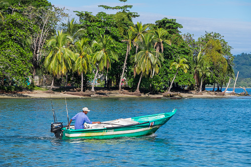 Limon, Costa Rica - September 15, 2022: Fisherman sailing off the coast of Puerto Viejo