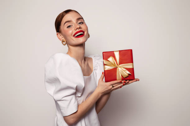 istock Beautiful emotional woman holding present box 1435377573